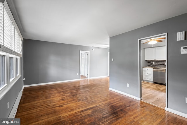 unfurnished living room featuring light wood finished floors, baseboard heating, baseboards, and a ceiling fan