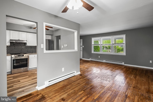 kitchen featuring appliances with stainless steel finishes, baseboard heating, a ceiling fan, and under cabinet range hood