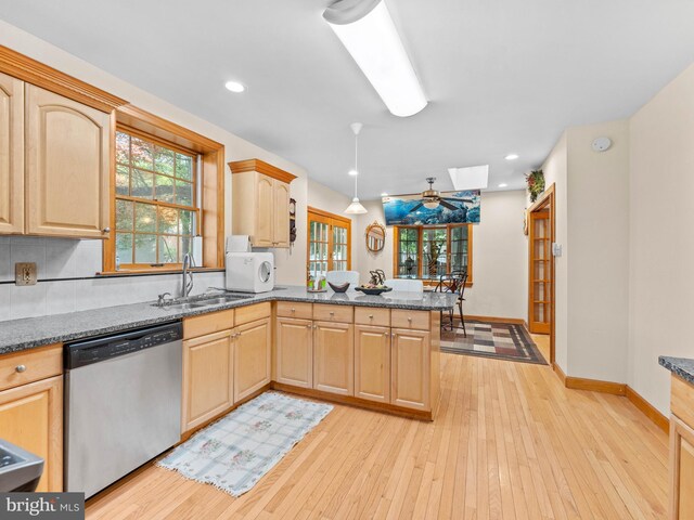 kitchen featuring dishwasher, a sink, light brown cabinetry, and recessed lighting