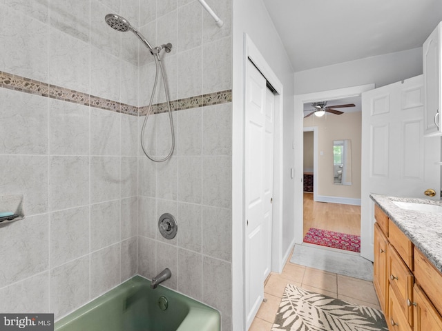 full bath with  shower combination, tile patterned flooring, ceiling fan, and vanity