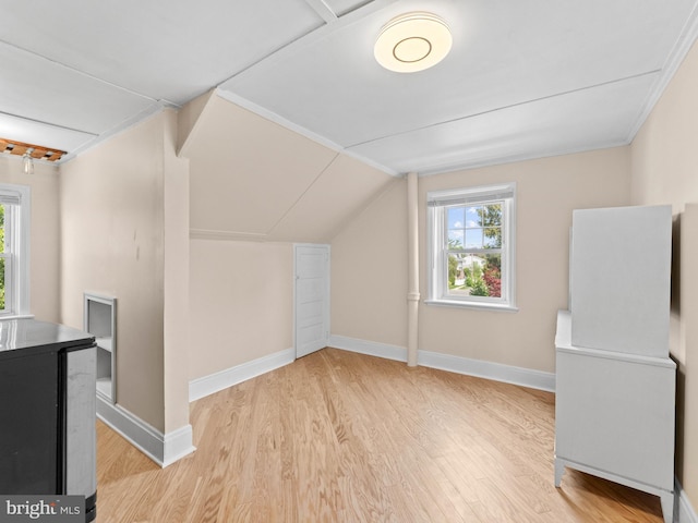 bonus room with light wood finished floors, healthy amount of natural light, baseboards, and lofted ceiling