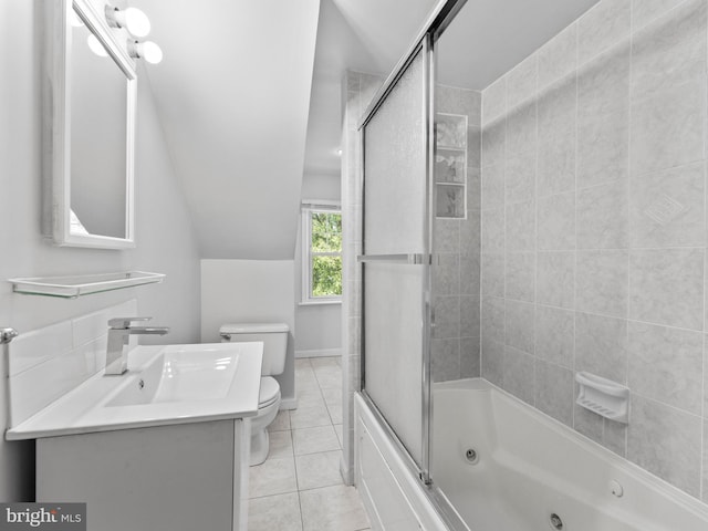 bathroom featuring tile patterned flooring, toilet, vanity, vaulted ceiling, and a combined bath / shower with jetted tub