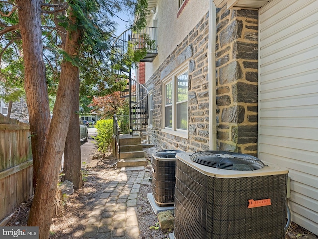 view of patio / terrace with central air condition unit, stairway, and fence