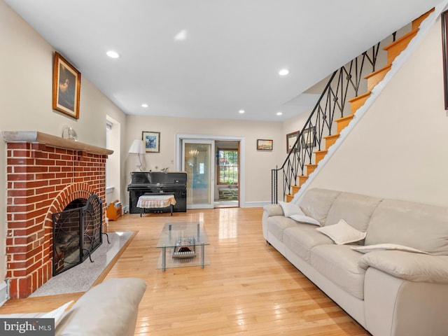 living room featuring hardwood / wood-style flooring, recessed lighting, a fireplace, baseboards, and stairs