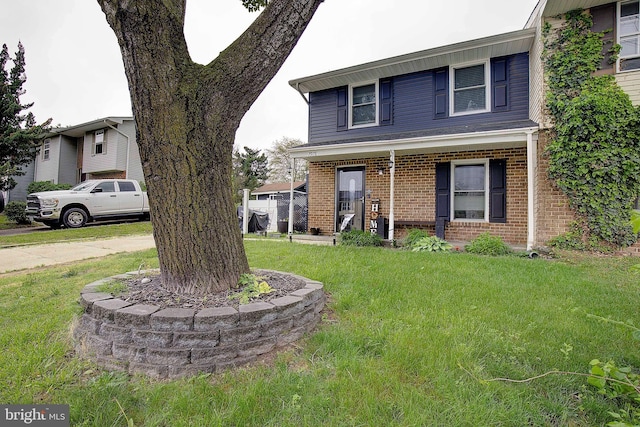 view of front facade featuring brick siding and a front yard