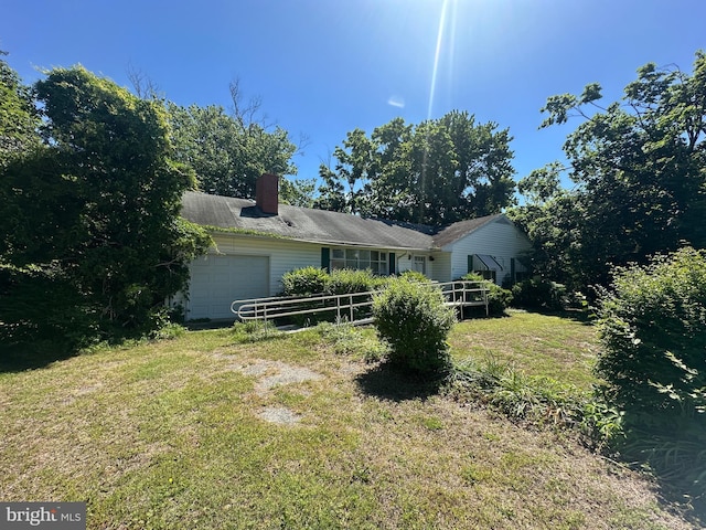 5521 Whitehall Rd, Cambridge, MD 21613 - view of front facade with a garage, a front yard, and a chimney