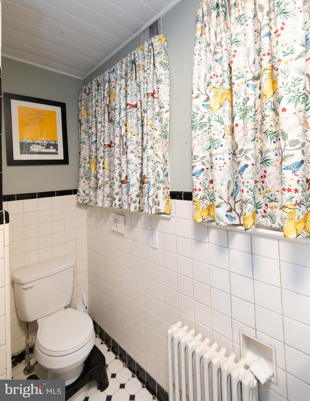 116 Oakley St, Cambridge, MD 21613 - bathroom featuring radiator heating unit, tile walls, and a wainscoted wall