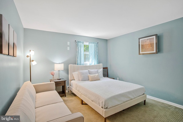 bedroom with light colored carpet and baseboards