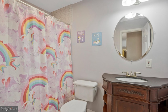 bathroom with toilet, vanity, a shower with curtain, and baseboards