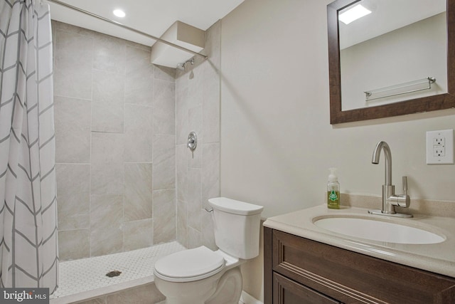 full bath featuring a tile shower, toilet, and vanity
