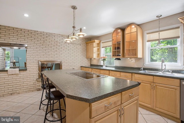 kitchen featuring a sink, brick wall, light tile patterned flooring, dark countertops, and black electric stovetop