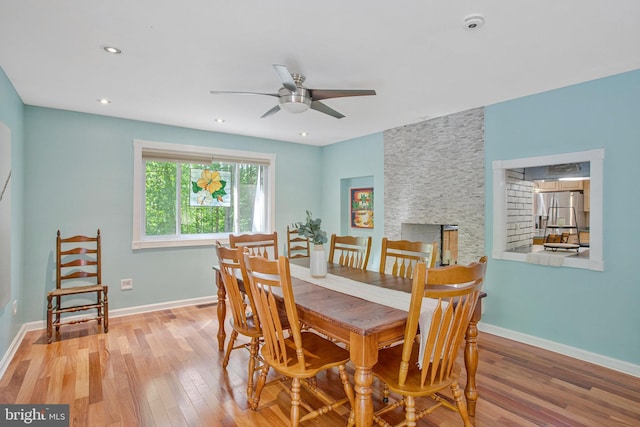 dining room with wood finished floors, a ceiling fan, baseboards, and recessed lighting