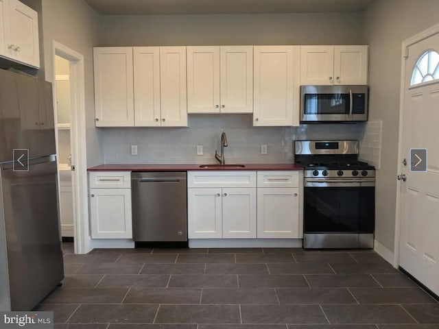 137 S 49th St, Philadelphia, PA 19139 - kitchen with appliances with stainless steel finishes, a sink, backsplash, and white cabinetry