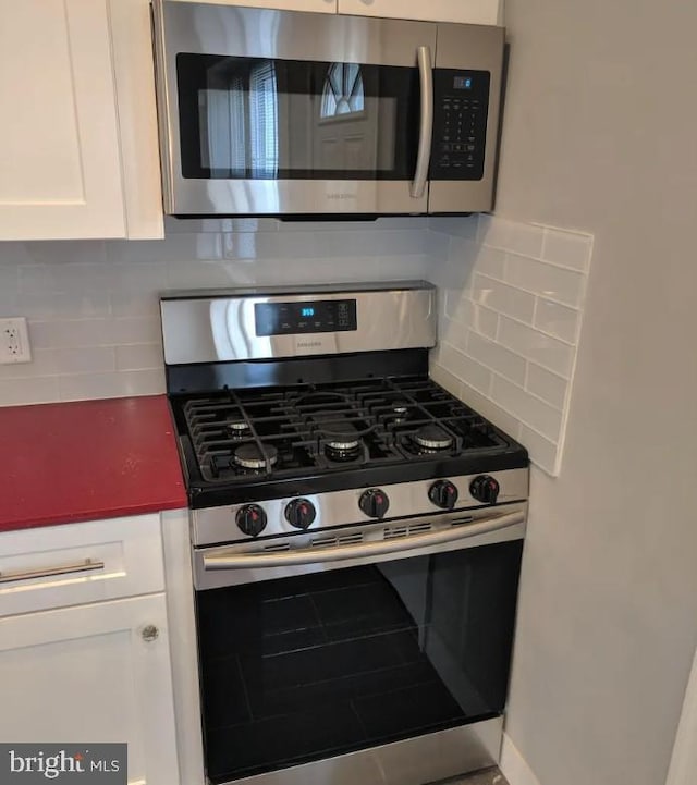 137 S 49th St, Philadelphia, PA 19139 - kitchen featuring appliances with stainless steel finishes, white cabinets, and backsplash