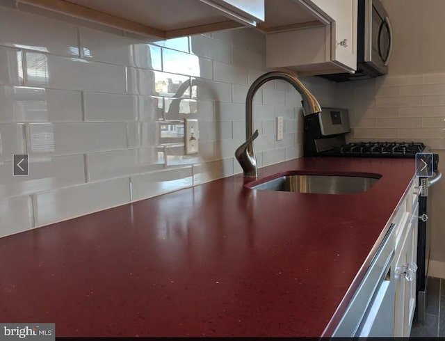 137 S 49th St, Philadelphia, PA 19139 - kitchen view of a sink, dark countertops, dishwasher, stainless steel microwave, and decorative backsplash