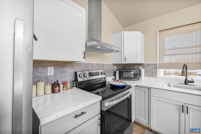 kitchen with a sink, stainless steel electric range, a toaster, wall chimney exhaust hood, and decorative backsplash