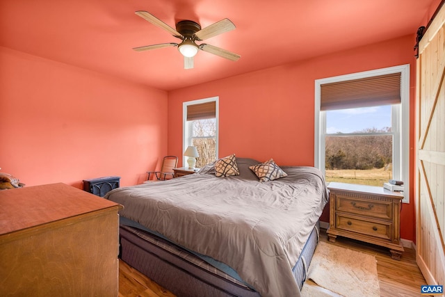 bedroom with light wood-type flooring and ceiling fan