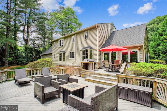wooden deck with an outdoor living space with a fire pit and outdoor dining space