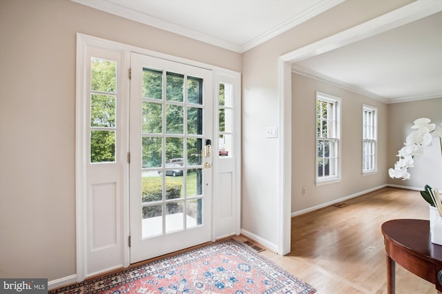 doorway featuring crown molding, light wood finished floors, and baseboards