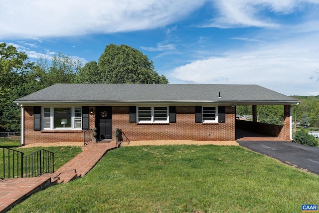 single story home featuring driveway, an attached carport, brick siding, and a front lawn