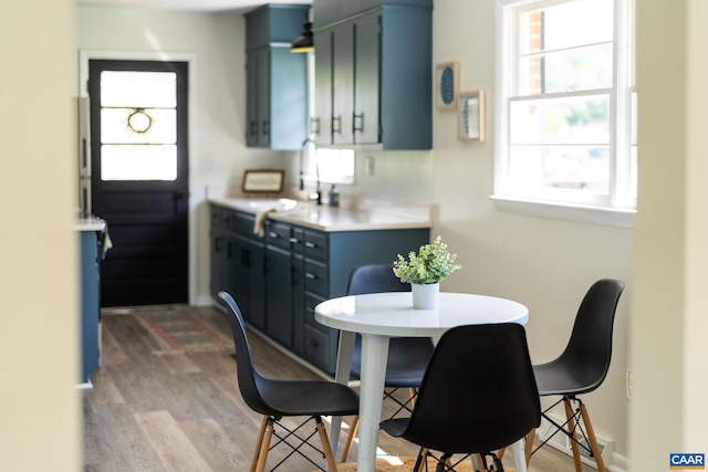 kitchen featuring blue cabinets, light wood finished floors, and a healthy amount of sunlight