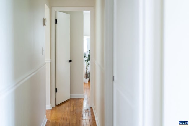 hall with baseboards and light wood-style floors