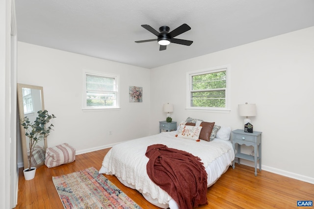 bedroom with ceiling fan, baseboards, and wood finished floors