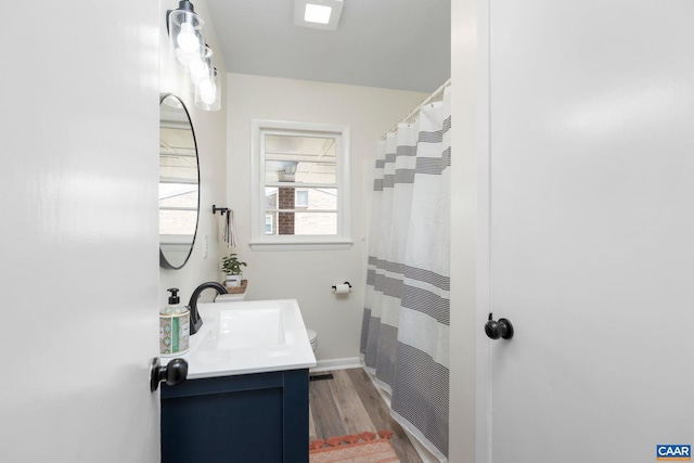 full bath featuring baseboards, wood finished floors, vanity, and a shower with shower curtain