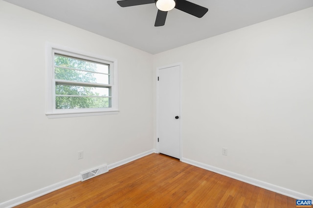 unfurnished room featuring baseboards, light wood-type flooring, visible vents, and a ceiling fan