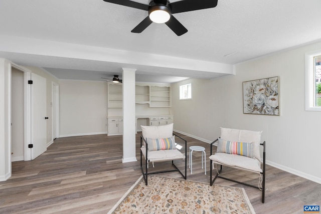 sitting room with baseboards, a ceiling fan, and wood finished floors