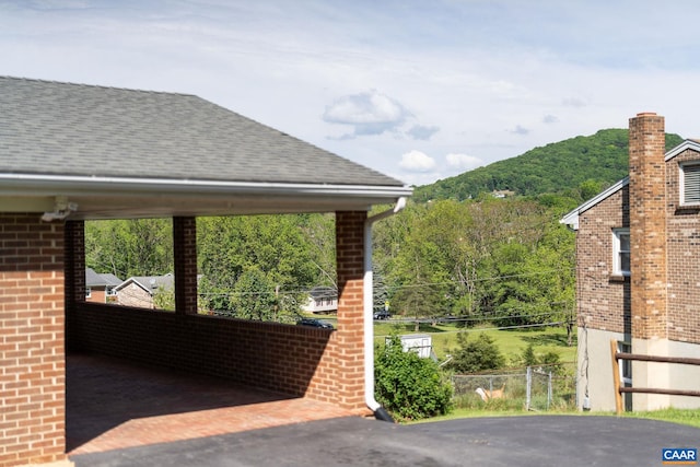 exterior space featuring a wooded view and fence