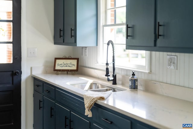 kitchen with light countertops, a sink, and blue cabinetry