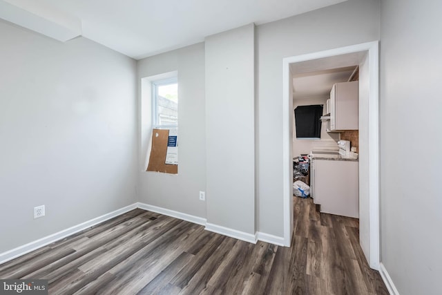 2108 E Hoffman St, Baltimore, MD 21213 - spare room featuring baseboards and dark wood-style flooring