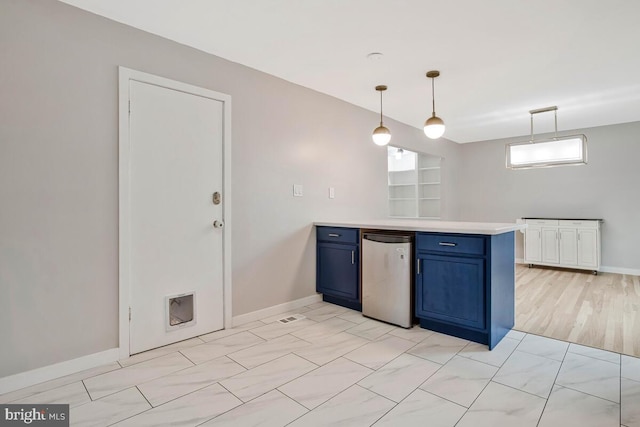kitchen with blue cabinetry, refrigerator, a peninsula, light countertops, and baseboards