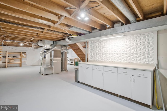 unfinished basement with gas water heater, heating unit, and stairway