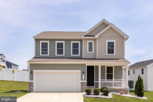 craftsman-style home with a porch, a front yard, an attached garage, and driveway
