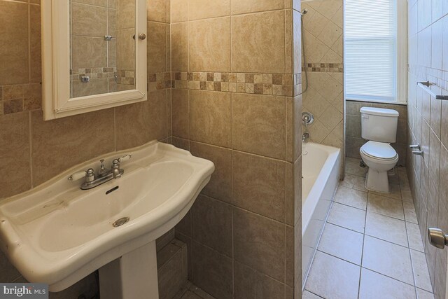2014 Penrose Ave, Baltimore, MD 21223 - bathroom featuring tile walls, toilet, a sink, and tile patterned floors