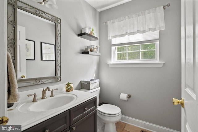 bathroom featuring toilet, vanity, tile patterned floors, and baseboards