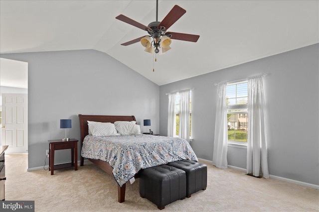 bedroom with vaulted ceiling, light colored carpet, baseboards, and a ceiling fan