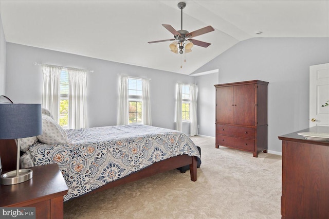 bedroom featuring vaulted ceiling, light colored carpet, and a ceiling fan