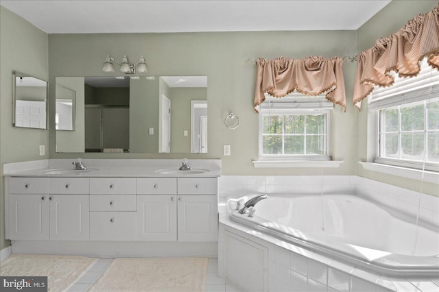 bathroom featuring a garden tub, double vanity, and tile patterned flooring