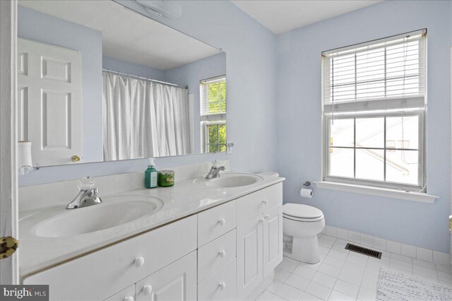 full bathroom with toilet, tile patterned flooring, double vanity, a shower with curtain, and baseboards