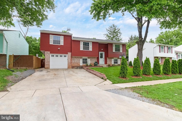 bi-level home featuring an attached garage, driveway, and brick siding