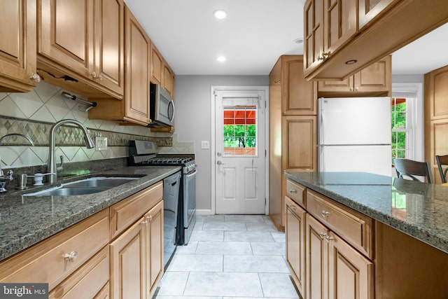 kitchen with stainless steel appliances, a sink, healthy amount of natural light, tasteful backsplash, and recessed lighting