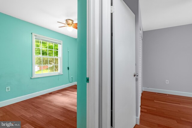 hallway with wood finished floors and baseboards