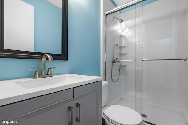full bath featuring toilet, a shower stall, and vanity