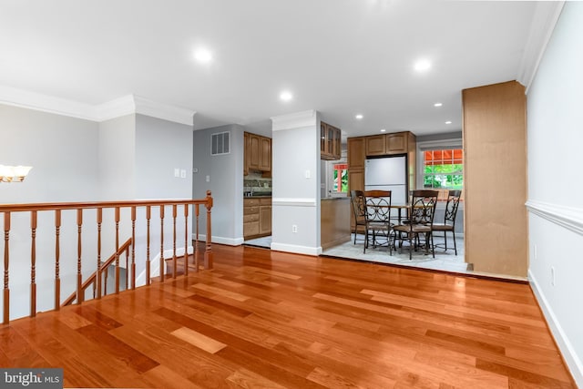 dining room featuring light wood-style floors, crown molding, recessed lighting, a chandelier, and baseboards