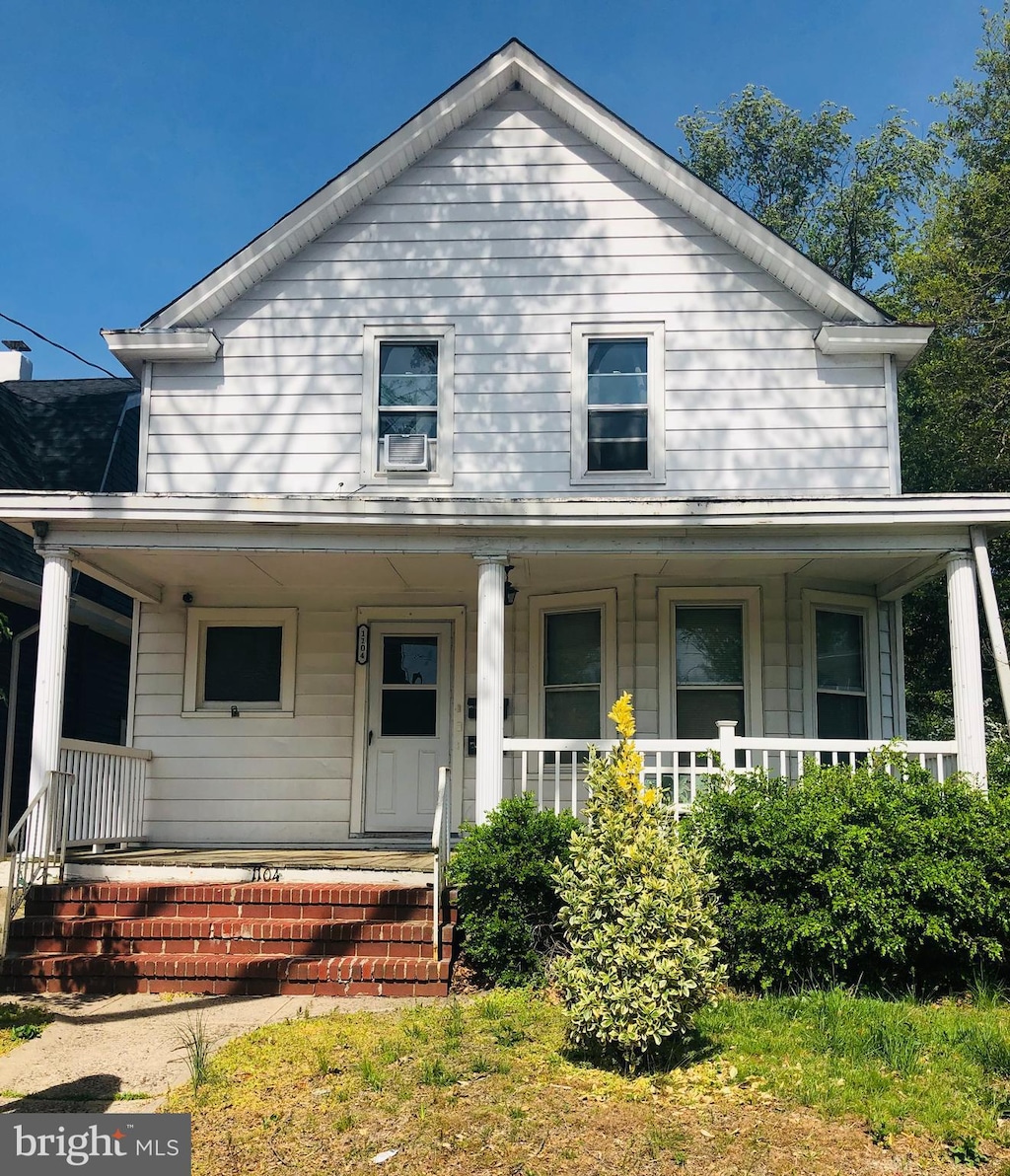 farmhouse with a porch and cooling unit