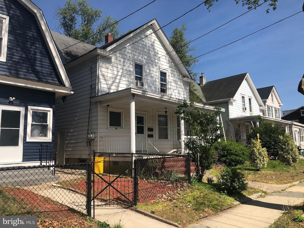 view of front of property featuring covered porch, a fenced front yard, and a gate