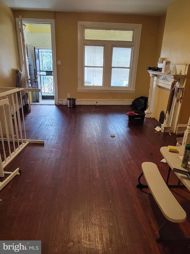 living area with wood-type flooring, healthy amount of natural light, and baseboards